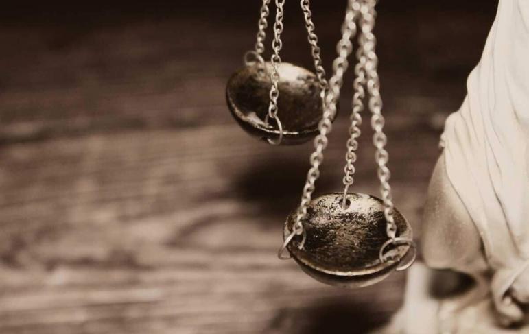 A close-up of the Scales of Justice held by a statue, symbolizing fairness, legal expertise, and professional representation.