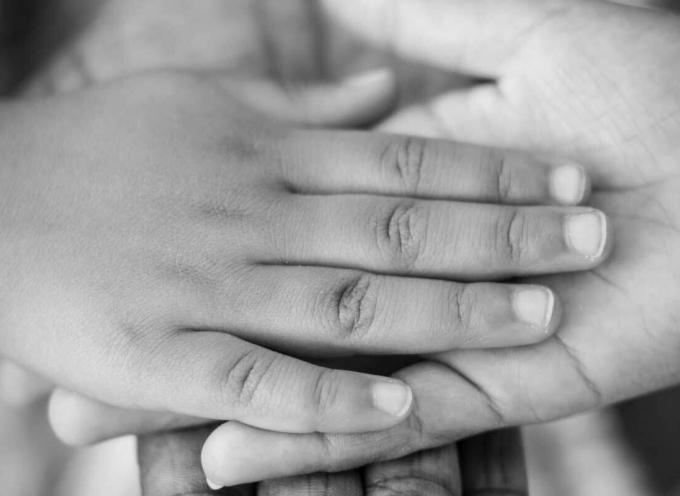 A childs hand being held by an adult