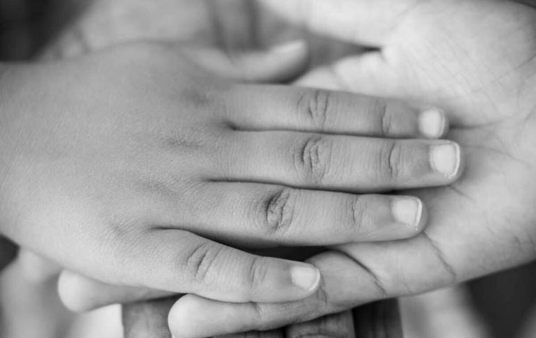 A childs hand being held by an adult